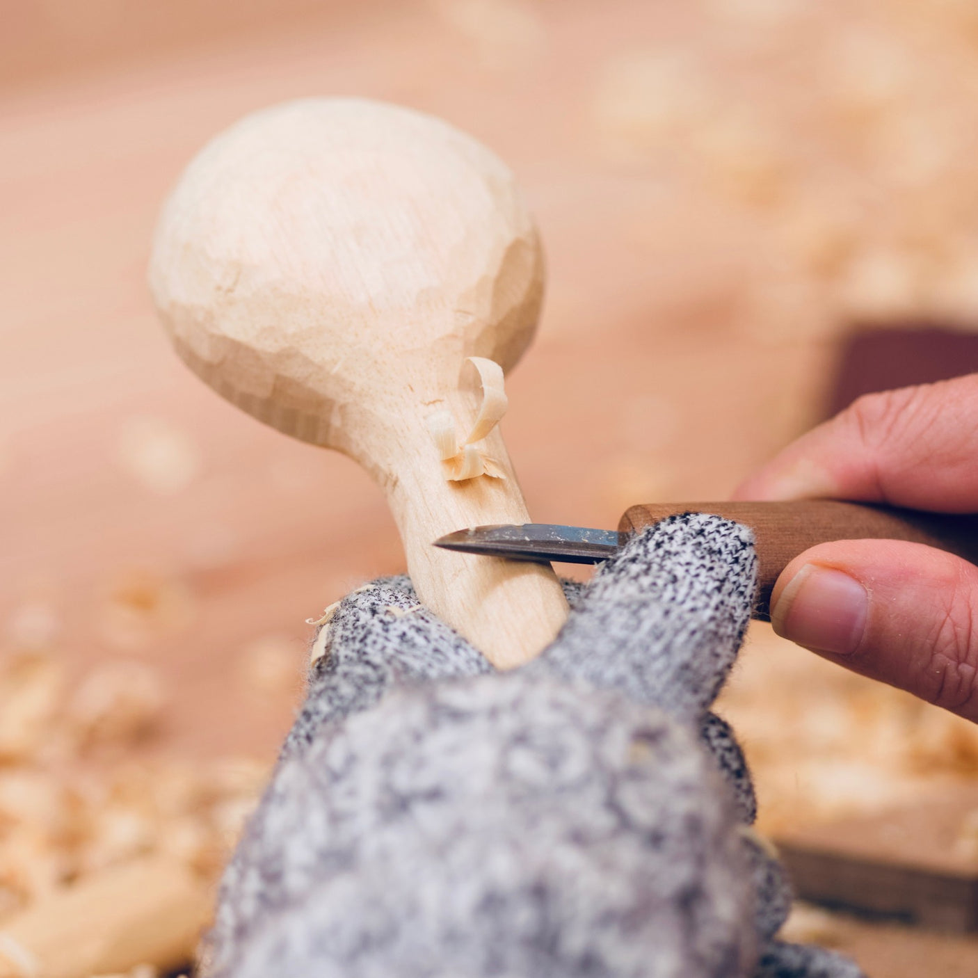 Person carving a mushroom with a knife on a textured surface