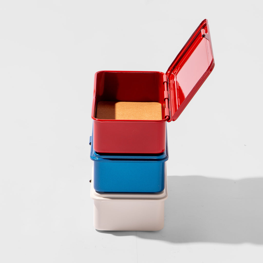 Stack of colorful rectangular containers with a red top on a white background