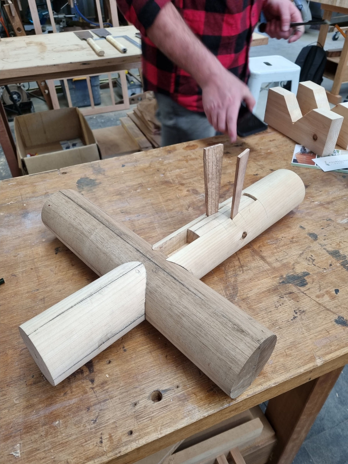 A Japanese timber joint being fitted together on a workbench